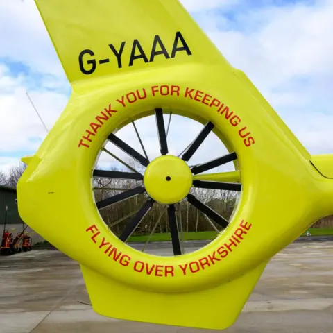 Yorkshire Air Ambulance The tail bumper of one of the air ambulance helicopters. It is bright yellow. Painted on in red lettering is "Thank you for keeping us flying over Yorkshire". 