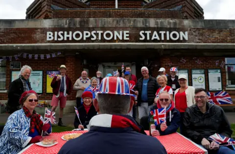 Reuters A view of a group of street party attendees gather outside Bishopstone Station wearing union hats and waving union flags, in Seaford.