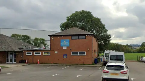 Google The front entrance of the rugby club with a view of the car park outside and a rugby pitch in the background