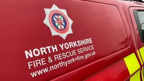 A red fire engine with the logo of North Yorkshire Fire & Rescue Service on the side