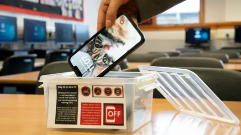 PA A student places a mobile phone in a box before the start of a lesson at Stonelaw High School in Rutherglen.