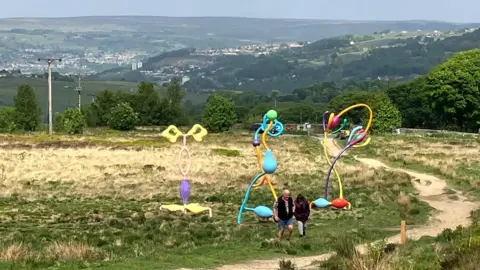 A number of sculptures on a moorland