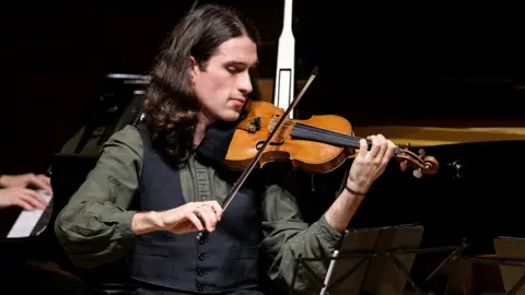 BBC David Lopez Ibanez plays the violin on a stage