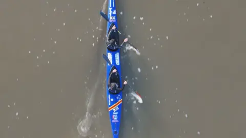 Mission Memory A blue kayak travels through the water.
