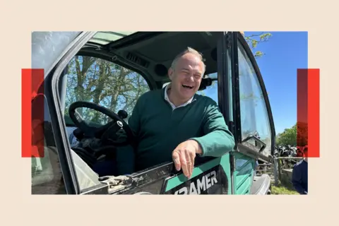 PA Wire Liberal Democrats leader Sir Ed Davey sits in the cab of telehandler during a visit to Stanbridge dairy farm