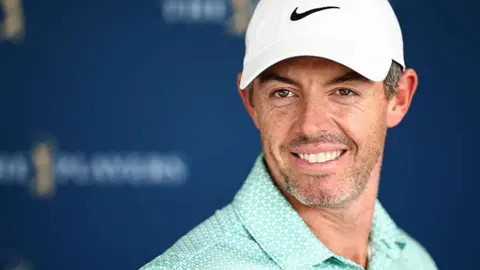 Rory McIlroy wearing a baseball cap and smiling