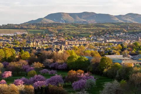 Jamie McDermaid A scene in Edinburgh with trees, flowers and hills in the background.