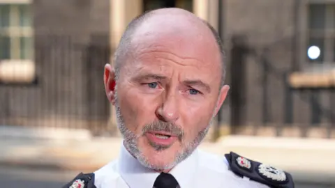 Reuters A head and shoulders pictures of Chief Constable Gavin Stephens, he is in uniform speaking at an earlier unrelated interview outside downing street which is visible blurred in the background