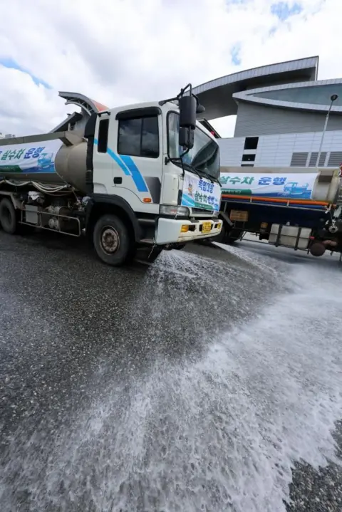 EPA A sprinkler truck sprays water on the road