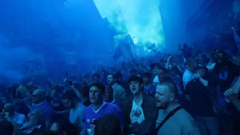 Reuters The air turned blue with flares ahead of kick-off with a large crows pictured in blue smoke