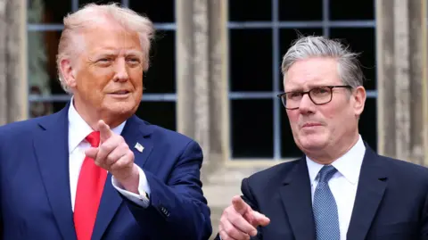US President Donald Trump and British Prime Minister Sir Keir Starmer point at something in the distance.