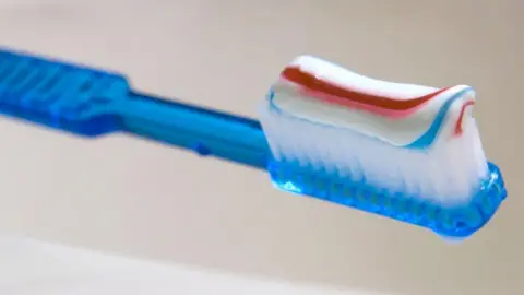 AFP via Getty Images Stripy toothpaste on a toothbrush
