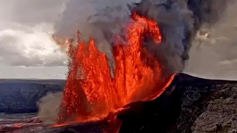 Red lava and smoke shoots from black mountains into the air