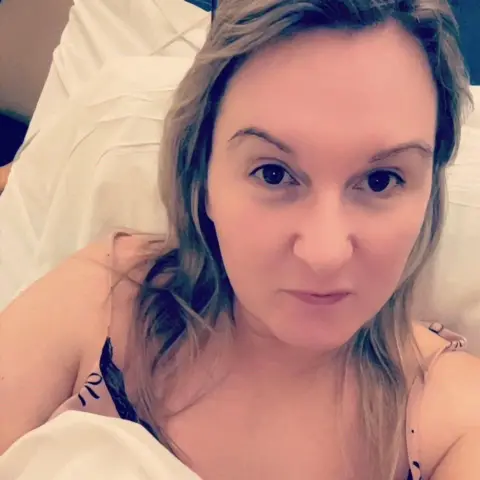 Gemma Doherty A woman in a hospital bed posing for a selfie.