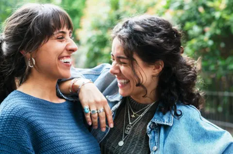 Getty Images Two adult female friends laughing together