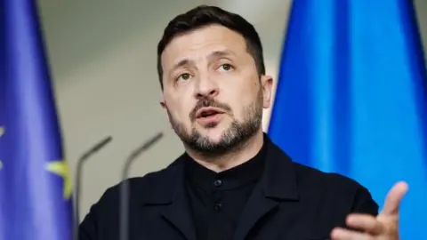 Ukrainian President Volodymyr Zelensky gestures as he speaks during a joint press conference with German Chancellor Friedrich Merz
