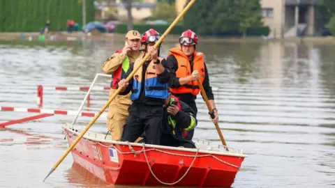 I soccorritori dell'Agenzia per la protezione dell'ambiente utilizzano i pali per spostare una zattera nelle aree allagate a Cikovice-Dziedice, nel sud della Polonia