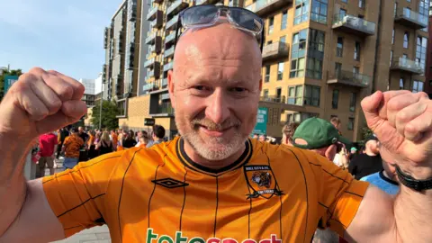 BBC / Linsey Smith A bald man wearing a Hull city shirt holds his fists aloft 