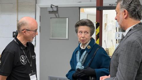 Princess Anne speaks to workers at a factory