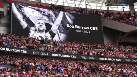 PA Media The large stadium screen showing a tribute to former Leeds Rhinos player Rob Burrow during the Betfred Challenge Cup final at Wembley Stadium