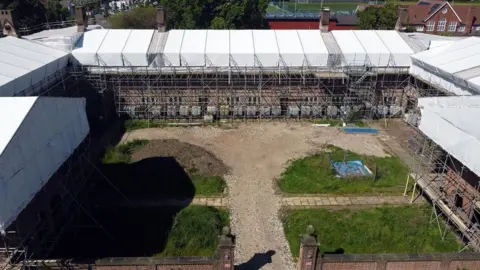 The fire-damaged Henderson Old Hall with a temporary covering in place to protect the building's remains from the weather