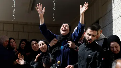 A mourner reacts during the funeral of three Palestinians killed during an attack by Israeli settlers in the village of Abu Falah, near Ramallah, in the Israeli-occupied West Bank (9 March 2026)
