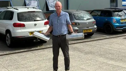 Peter Kilcoyne A picture of Steve Kilcoyne holding an exhaust component in each hand.