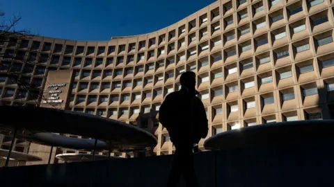 Shadow of man stands in front of government building