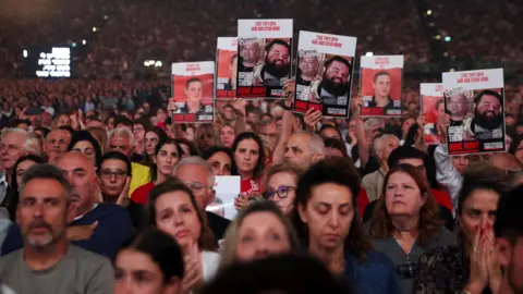 Reuters Israelis hold up posters demanding the release of hostages still being held in Gaza, at a mass march marking the second anniversary of the Hamas-led attack on Israel, in Tel Aviv, Israel (October 7, 2025).
