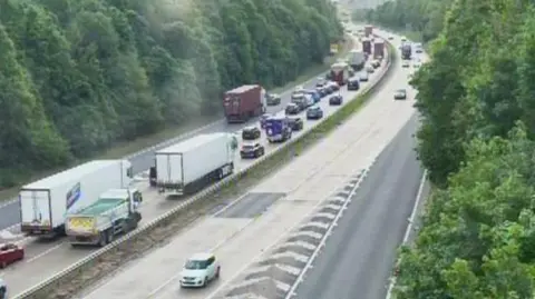 A traffic camera showing long queues of vehicles heading towards the Orwell Bridge in Ipswich. The other side - the westbound carriageway - is clear.