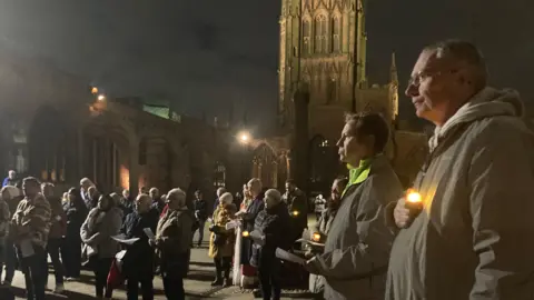 Dozens of people gather to take part in a candlelit vigil at Coventry Cathedral.