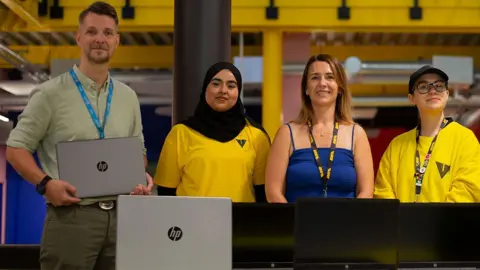 From l-r Chris Hatton, University of Lancashire’s Head of Technical Services - Technology Operations and Creative Industries; youth worker and University degree apprentice Maryam Ali; Natalie Dugdale, Chief Operating Officer at Vault Youth Zone; youth worker and University degree apprentice Gemma Unsworth with the laptops