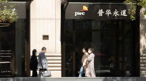 Four people walking past PwC office in Shanghai