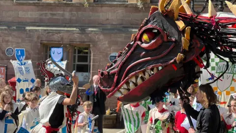 Knights fight a huge puppet dragon