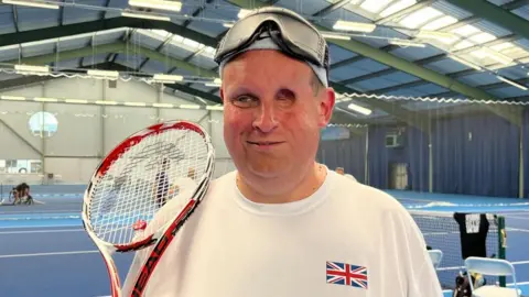 Gavin Griffiths smiling for the camera in the Nottingham Tennis Centre.
