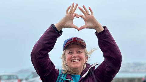 Image of Clare holding a heart up in the air