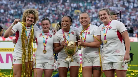PA Media (left to right) England's Ellie Kildunne, Lucy Packer, Sadia Kabeya, Maddie Feaunati and Morwenna Talling celebrate with the Women's Rugby World Cup trophy after the Women's Rugby World Cup final at the Allianz Stadium, London