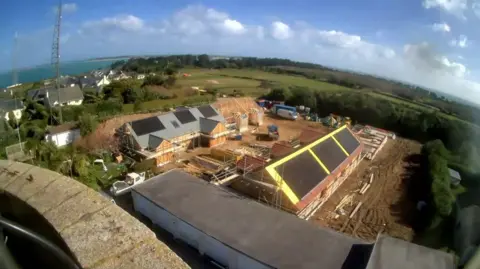Tim Dean A webcam picture from on top of a tower shows a birds eye view of 10 houses under construction 