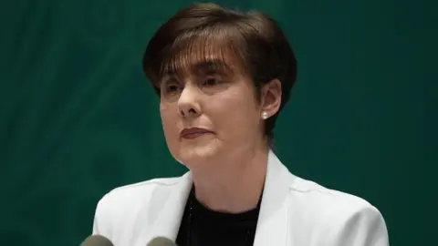 PA Media Irish Education Minister Norma Foley wearing a white jacket and a black top during a news conference