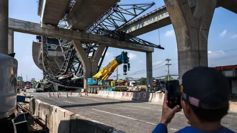 Wide shot of the wreckage of a crane that collapsed on a highway