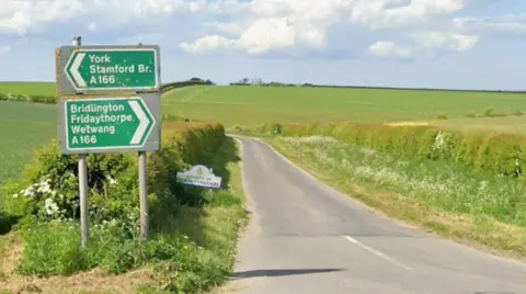 Google A screenshot from Google maps of a junction off the A166 - a road with fields on either side. 