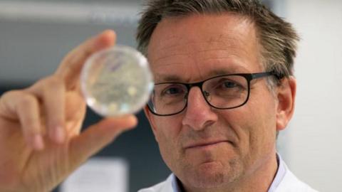 Michael Mosley holding up a petri dish