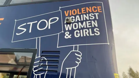 A blue Stagecoach bus painted with Stop Violence Against Women & Girls