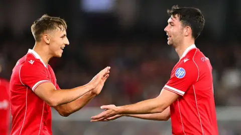 Max Cleworth celebrates with Wrexham team-mate Tom O'Connor