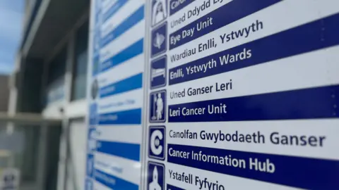 A hospital board listing different ward areas that are colour coded. 