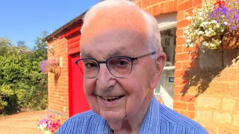 Jim Wright Jim Wright, stood outside his house, looking at the camera