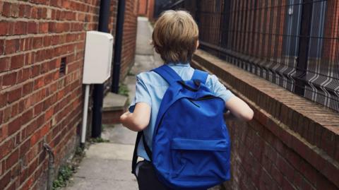 School pupil with a blue backpack