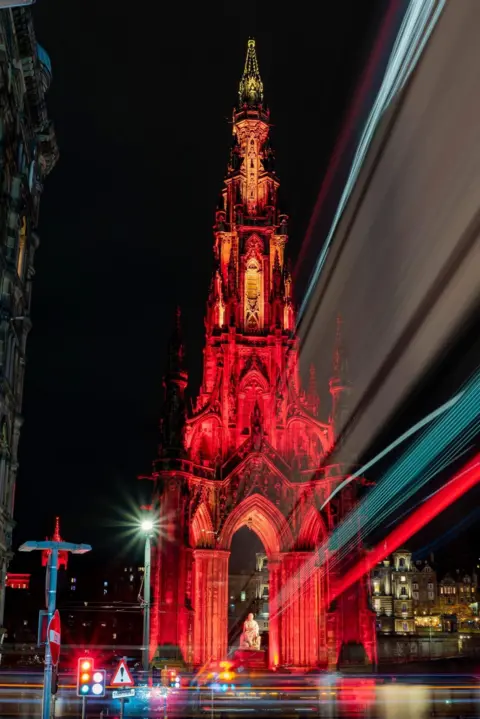 Graham Paton An image of the Scott Monument in Edinburgh, lit up red at night.