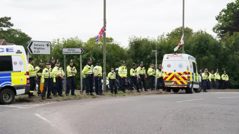 PA Media A line of police by the side of a road. 