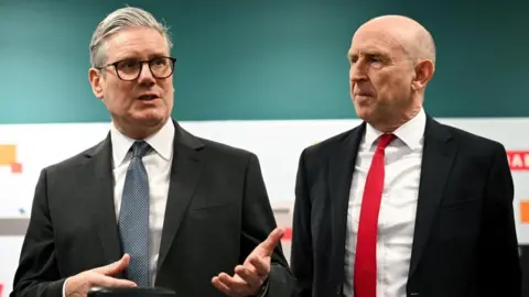 Sir Keir Starmer, left, stands next to John Healey